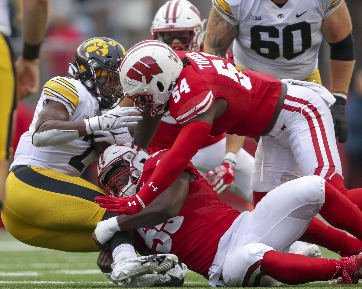 Oct 14, 2023; Madison, Wisconsin, USA; Wisconsin Badgers linebackers Maema Njongmeta (55) and Jordan Turner (54) tackle Iowa Hawkeyes running back Kaleb Johnson (2) at Camp Randall Stadium. Mandatory Credit: Tork Mason-USA TODAY Sports
